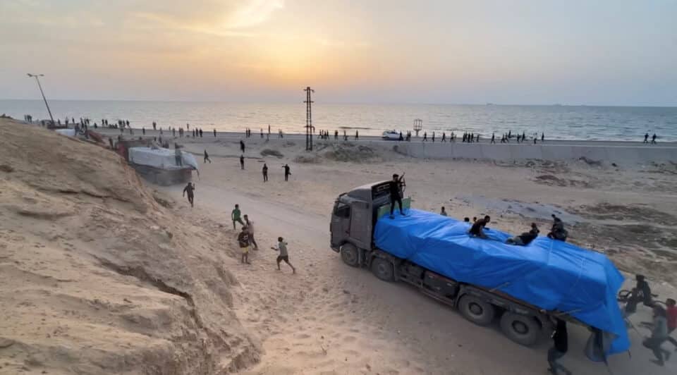 Trucks-carrying-aid-delivered-into-Gaza-via-a-U.S.-built-pier-move-as-seen-from-central-Gaza-S...jpg