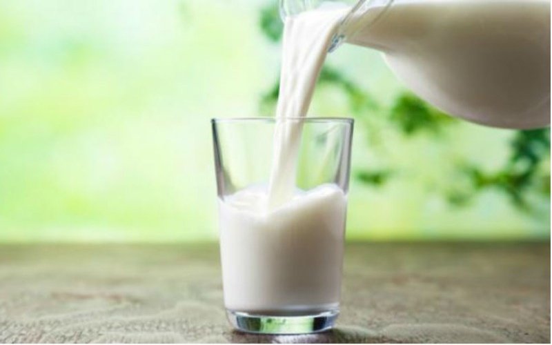 pouring_milk_in_the_glass_on_the_background_of_nature.jpg